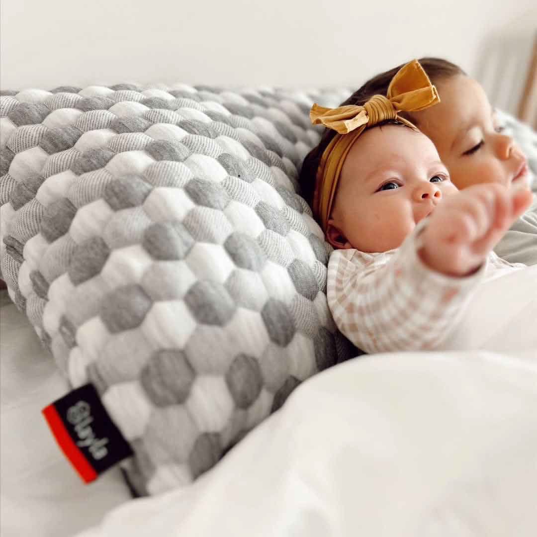 Two babies laying on the kapok pillow